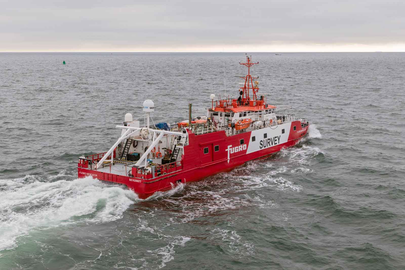A survey ship named Fugro navigates through a choppy sea under an overcast sky.